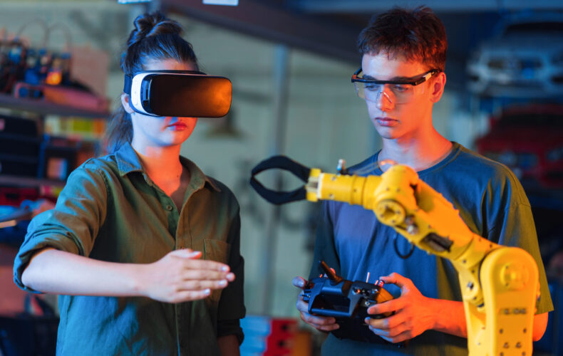 Teens doing experiments in robotics in a laboratory. Boy in protective glasses and girl in VR headset controlling the robot using controller and hand. Red and blue illumination